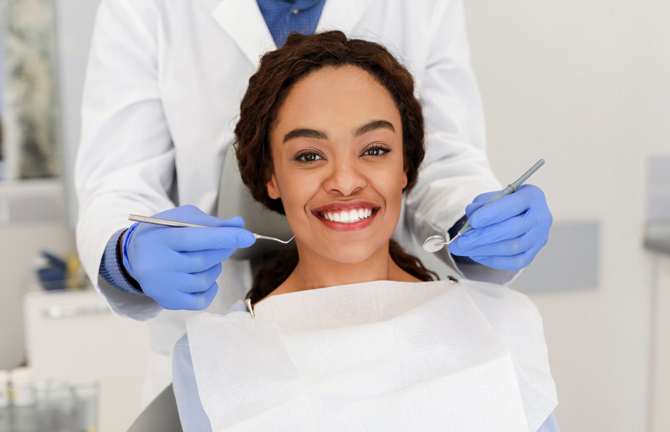 Dentist examining a patient's teeth before a tooth extraction at Myrtle Grove Implant & Family Dentistry