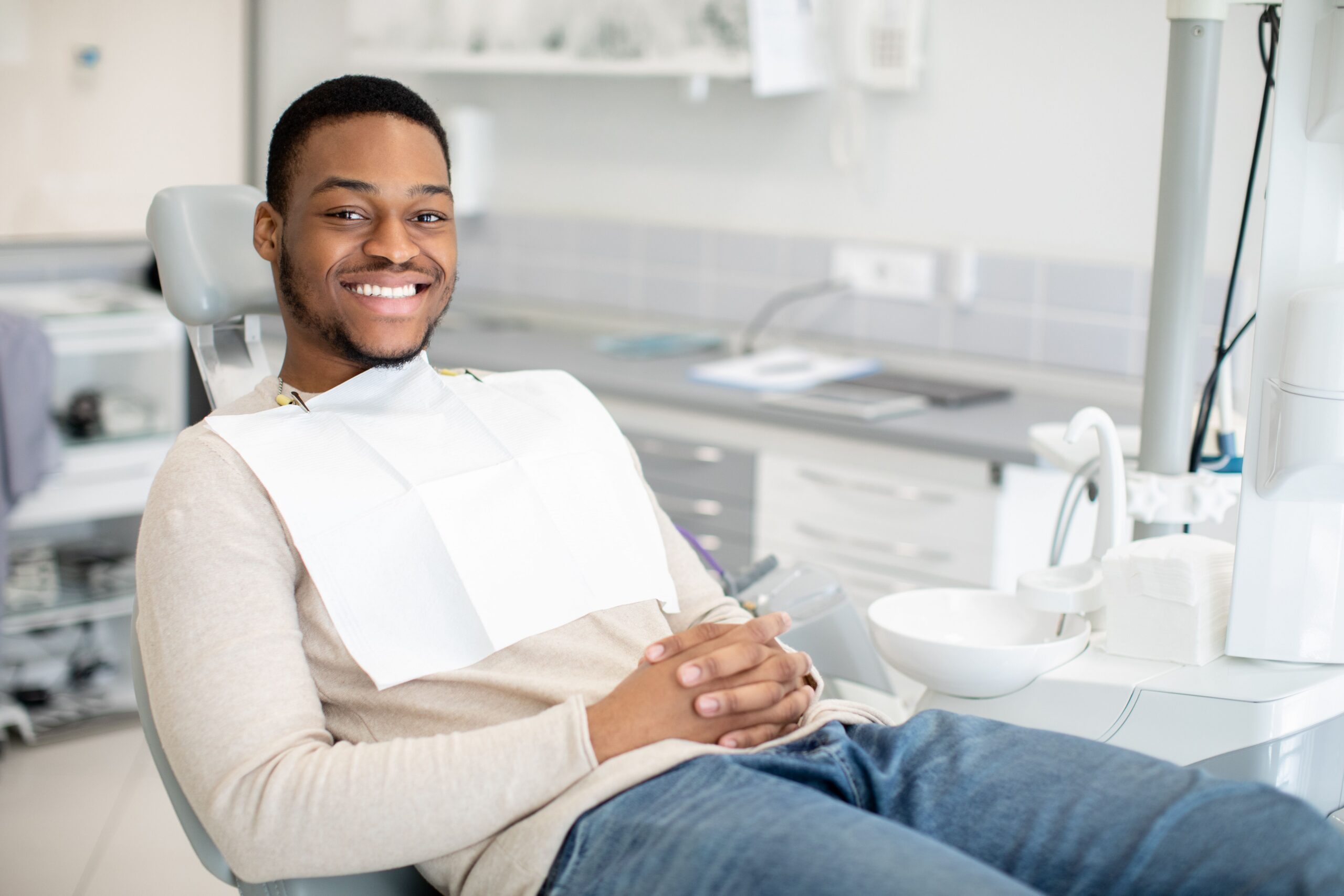 Smiling male patient sitting in the dental chair after a tooth extraction at Myrtle Grove Implant & Family Dentistry